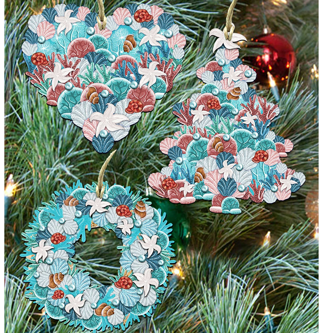 a Christmas tree decorated with three ornaments. The ornaments are shaped like hearts, trees, and wreaths, all adorned with seashells and other marine elements.
