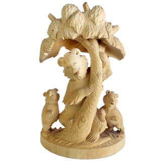 A wooden sculpture depicting a bear sitting on a tree branch with two smaller bears on either side.