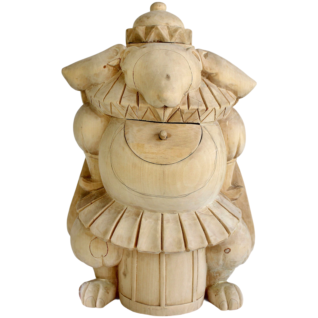 A wooden sculpture of a whimsical, fantastical creature with a large head, a ruffled skirt, and a pointed hat.