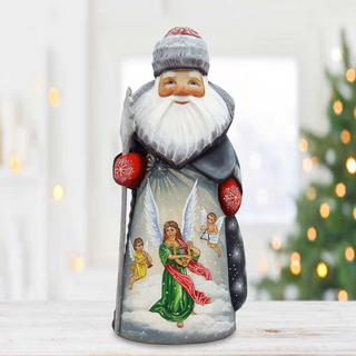 A hand-painted figurine of Santa Claus with angels, set against a blurred background of a Christmas tree.