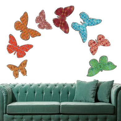 a green couch with colorful butterfly-shaped wall art above it.