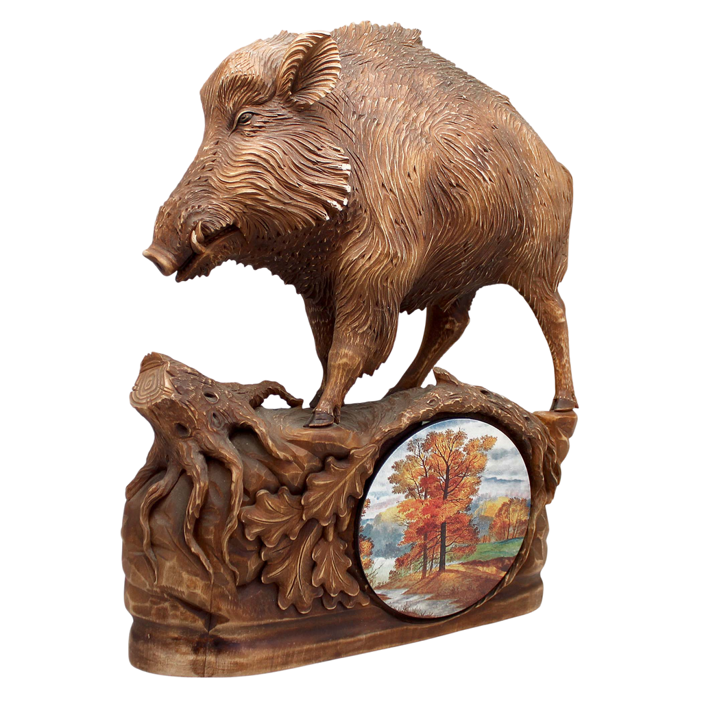 A wooden sculpture depicting a wild boar, with a circular panel below showing a landscape scene.