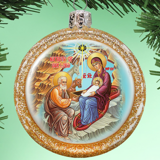 a Christmas ornament with a religious scene depicting the Nativity of Jesus Christ.