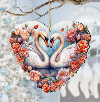 A heart-shaped ornament featuring two swans with their necks intertwined, surrounded by a floral arrangement of roses and other flowers.